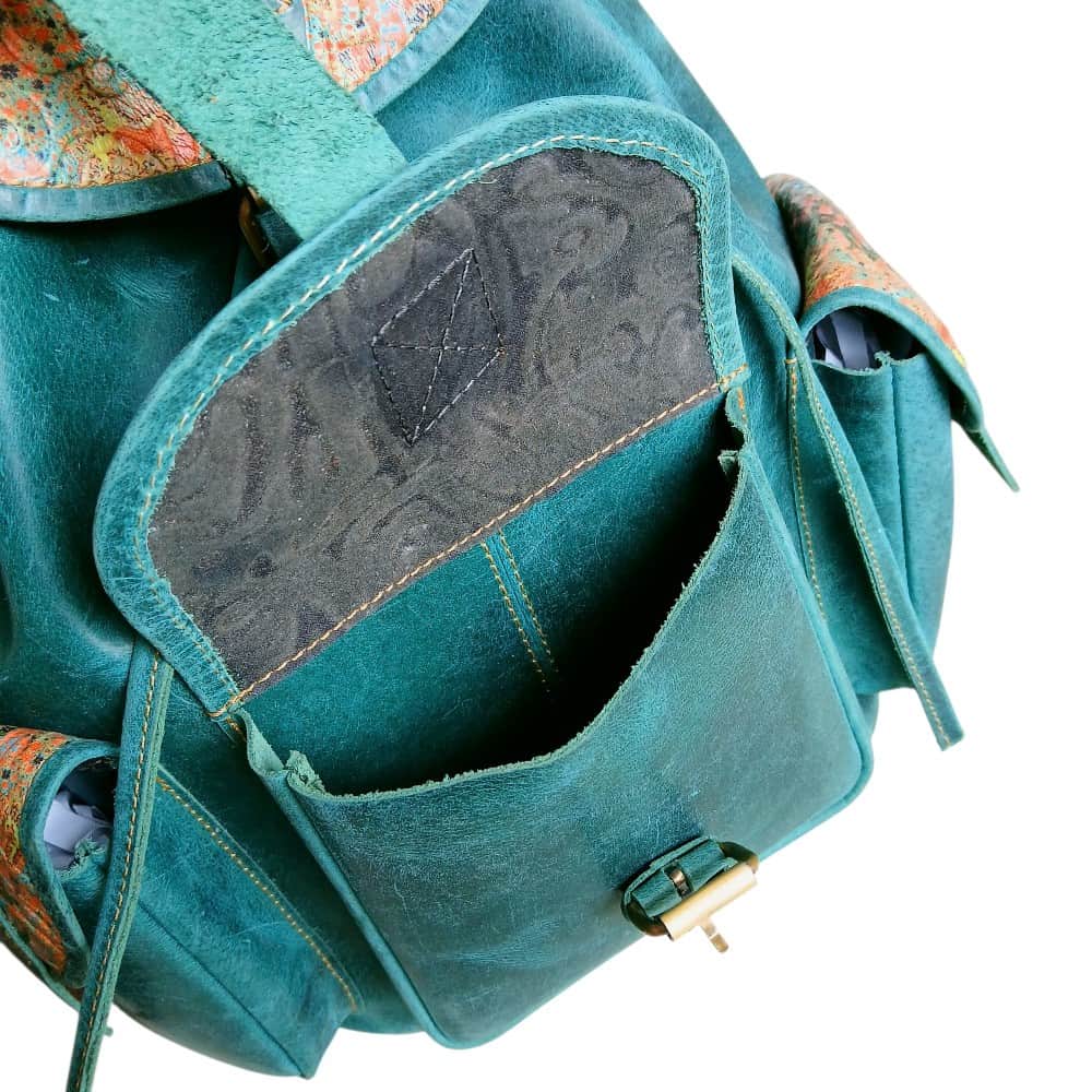 Close-up of printed floral leather flap on teal women's leather backpack — artisan handmade bag Pakistan
